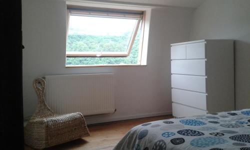a bedroom with a bed and a window at La petite maison in Aywaille