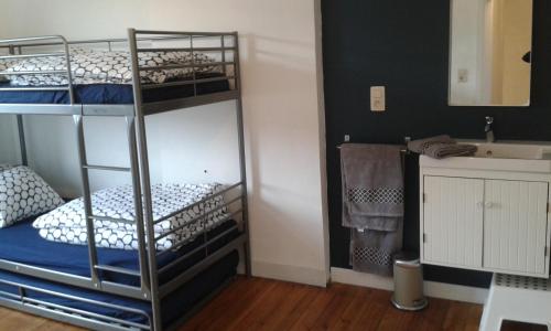 two bunk beds in a room with a sink at La petite maison in Aywaille