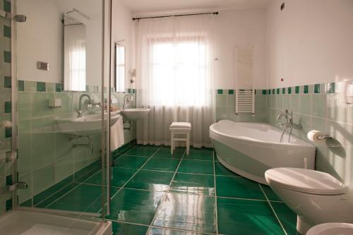 uma casa de banho com uma banheira, um lavatório e um WC. em Villa Tiboldi em Canale