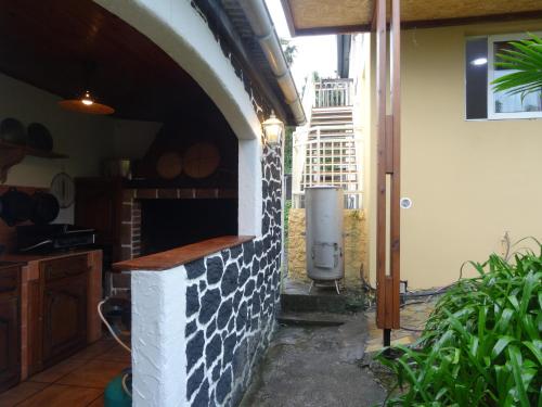 a kitchen with a brick fireplace in a house at Boule de bleu in Le Tampon