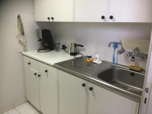 a kitchen with a sink and a counter top at Datacom Guest House in Nicosia