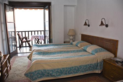 a bedroom with a large bed and a balcony at Maistrali Hotel in Afissos