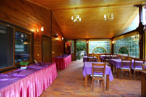 a dining room with tables and purple tablecloths at Bahçe Villa in Cıralı