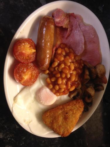 a plate of food with eggs bacon beans and meat at Abbey Court Guest House in Carlisle