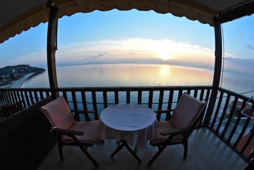 a table and chairs on a balcony with a view of the ocean at Maistrali Hotel in Afissos