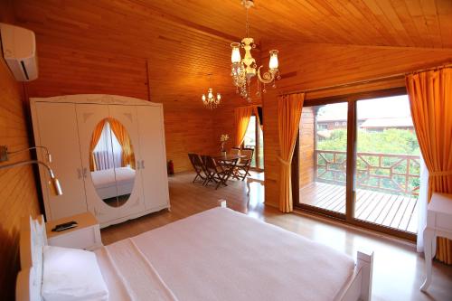 a bedroom with a bed and a balcony with a table at Bahçe Villa in Cıralı