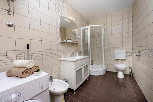 ein weißes Bad mit einem WC und einem Waschbecken in der Unterkunft Apartment Jelena in Molunat