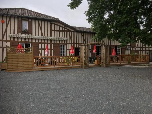 a building with a wooden fence and a house at La petite auberge in Châtelraould-Saint-Louvent