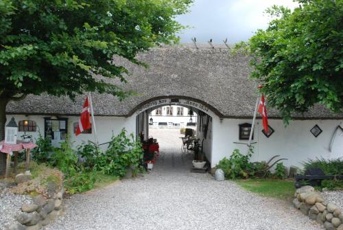 an entrance to a white building with a thatched roof at Svostrup Kro in Silkeborg