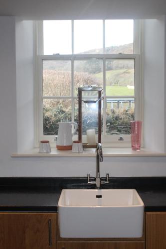 eine Küchenspüle vor einem Fenster in der Unterkunft Capel- Y-Bryniau in Pennal