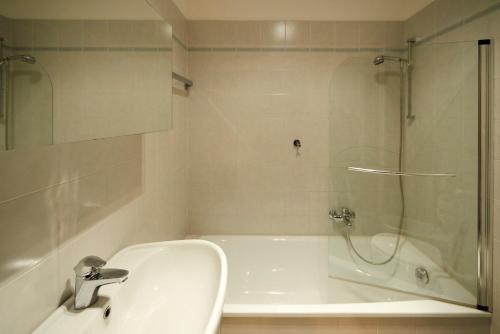 een badkamer met een douche, een bad en een wastafel bij Welcome Traveller LA PERLA APARTMENTS in Garda