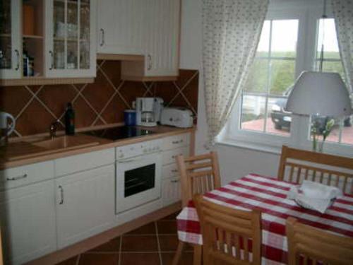 ネスマージールにあるDeichperle Nessmersielのキッチン(テーブル、シンク、テーブル、椅子付)