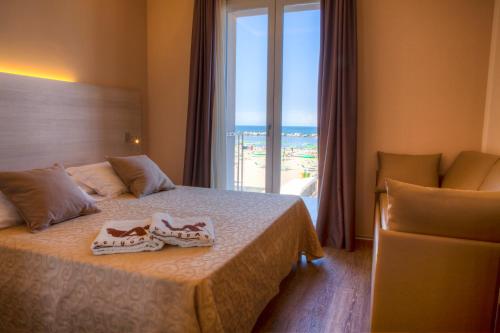 a hotel room with a bed and a window at Albergo Aquila in Rimini