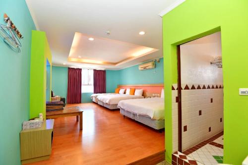a bedroom with two beds and green walls at Rock House in Eluan