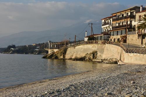 a bridge over a body of water next to buildings at Maistrali Hotel in Afissos