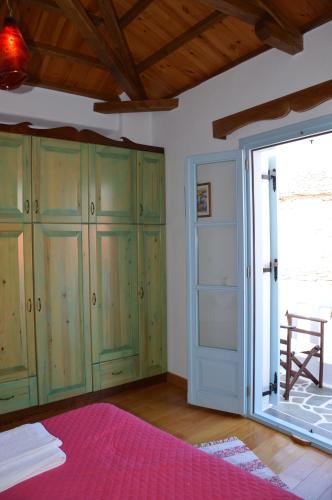 a bedroom with green cabinets and a sliding glass door at Stella's traditional house. in Alonnisos Old Town