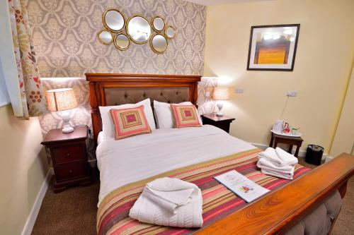 a bedroom with a large bed and two night stands at The Royal Victoria and Bull Hotel in Dartford