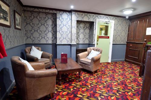 a living room with two chairs and a table at The Royal Victoria and Bull Hotel in Dartford