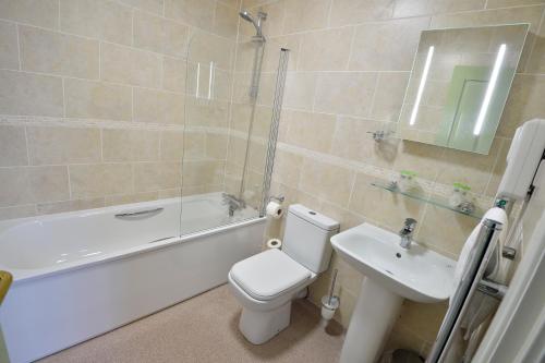 a bathroom with a white toilet and a sink at The Royal Victoria and Bull Hotel in Dartford
