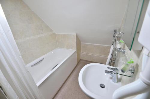 a bathroom with a sink and a tub and a toilet at The Royal Victoria and Bull Hotel in Dartford