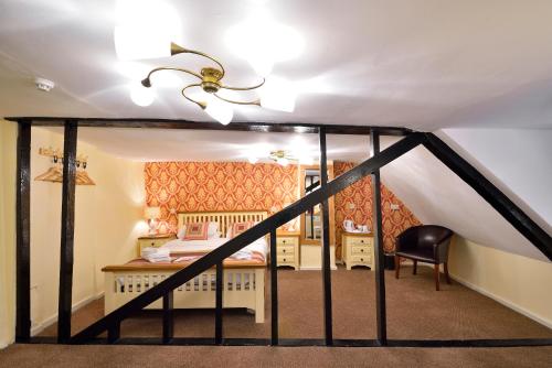 a attic bedroom with a bed and a desk at The Royal Victoria and Bull Hotel in Dartford
