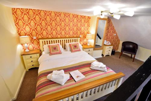 a bedroom with a bed with two towels on it at The Royal Victoria and Bull Hotel in Dartford