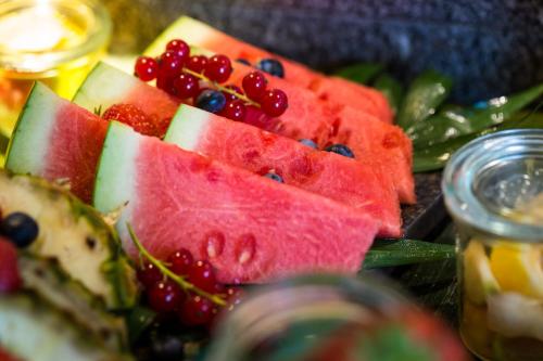 a plate of watermelon and other fruits and vegetables at Lindner Hotel Berlin Ku'damm, part of JdV by Hyatt in Berlin