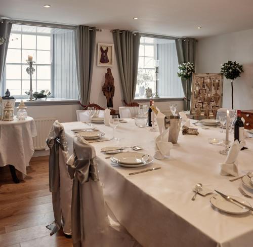 una mesa larga con manteles y servilletas blancas en Barrow House, en Tralee