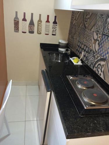 a kitchen with a counter top with bottles on the wall at Victory Flat Intermares in Cabedelo
