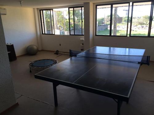 a ping pong table in a room with a tennis racket at Victory Flat Intermares in Cabedelo