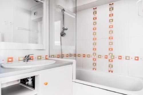 une salle de bain blanche avec un lavabo et une douche dans l'établissement Residence Le Pedrou - maeva Home, à Font-Romeu-Odeillo-Via