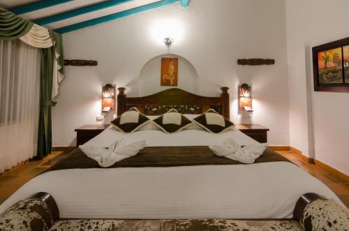 a hotel room with a large bed and two lamps at Hotel Antonio Nariño in Villa de Leyva