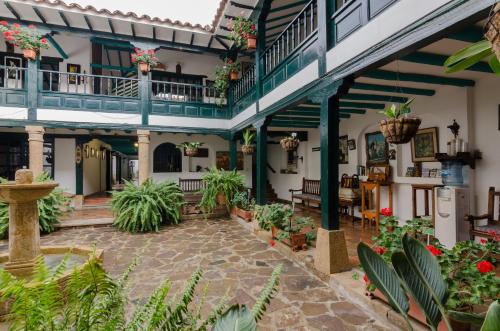 an indoor courtyard of a building with potted plants at Hotel Antonio Nariño in Villa de Leyva