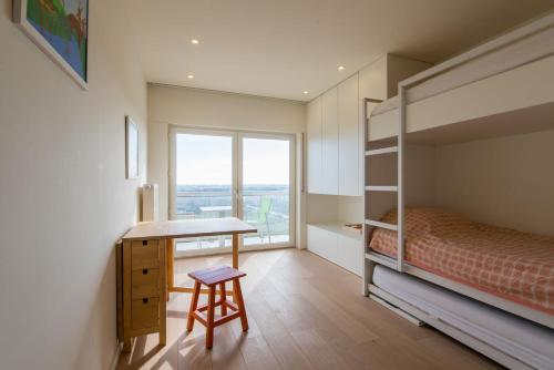 a bedroom with a bunk bed and a desk and a window at Apartment Sea View in Middelkerke