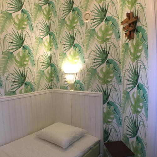 a room with a wallpaper with a bench and a lamp at Varbergs Vandrarhem in Varberg