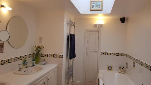 a bathroom with a sink and a toilet and a mirror at The Old Cottage in Arduaine