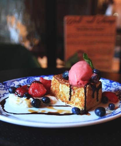 a piece of cake with fruit on a blue and white plate at Hotel Port-Royal in Quebec City
