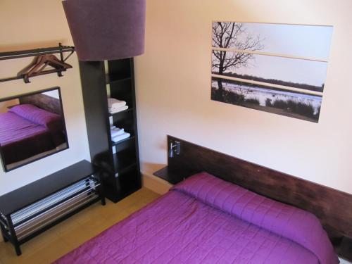 a bedroom with a purple bed and a mirror at Alberg Costa Brava in Llança
