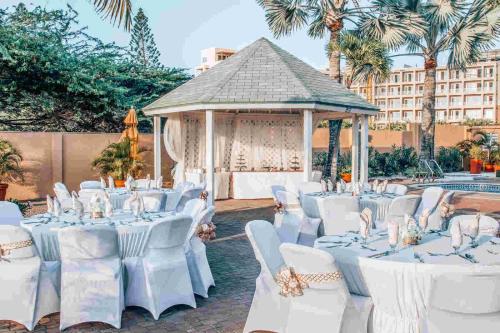a marquee with white tables and chairs and a gazebo at MVC Eagle Beach in Palm-Eagle Beach