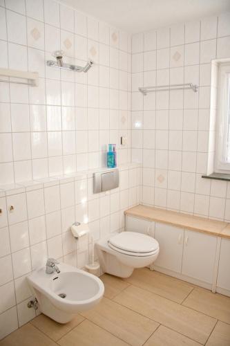 a white bathroom with a toilet and a sink at Ferienwohnungen Zeise in Leipzig