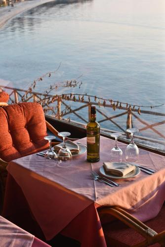a table with a bottle of wine and glasses on it at Maistrali Hotel in Afissos