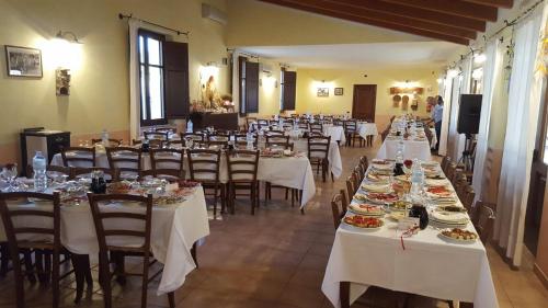 un comedor con mesas y sillas con platos de comida en Su Massaiu, en Turri