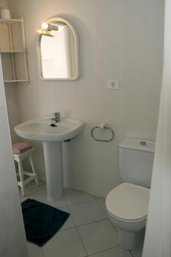 a white bathroom with a toilet and a sink at La Finca Uga in Uga
