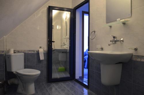 a bathroom with a toilet and a sink and a mirror at Хотел Калипсо Блу in Primorsko