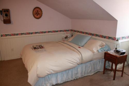 a bedroom with a large white bed and a table at Woodrow House Bed & Breakfast in Lubbock