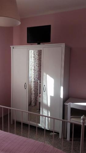 a room with a white cabinet with a television on top at Hotel Ristorante El Caracol in Mulazzo