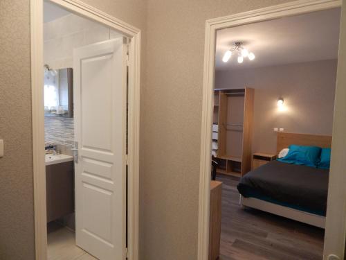 a bedroom with a bed and a mirror at Le Lion D'or in Ouroux en Morvan