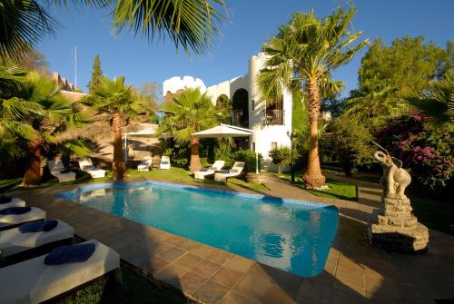 - une piscine avec une statue à côté d'une maison dans l'établissement Hotel Heinitzburg, à Windhoek