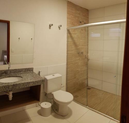 uma casa de banho com um chuveiro, um WC e um lavatório. em Bravo City Hotel Campo Grande em Campo Grande