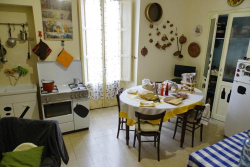 a kitchen with a table with chairs and a stove at La casa di Zia Mimina in Civitella Casanova